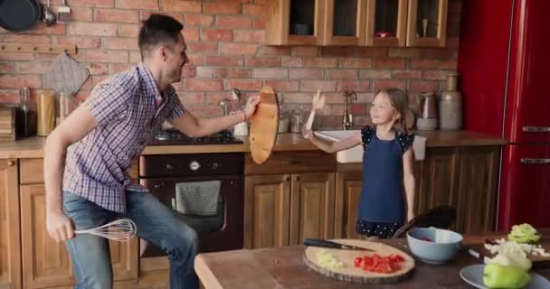 Szczęśliwy młody ojciec zabawy z małą córką w kuchni. — Wideo stockowe