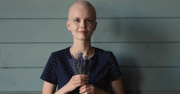 Jovem feliz com doença oncológica segurando flores nas mãos. — Vídeo de Stock