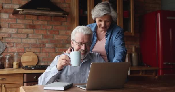 Glückliches Paar mittleren Alters kauft im Internet-Shop ein. — Stockvideo