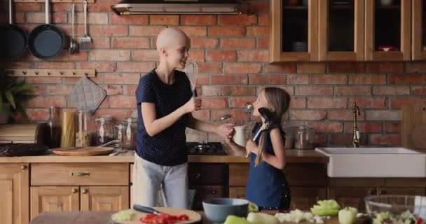 Feliz mujer calva divirtiéndose con su hija pequeña. — Vídeo de stock