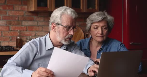 Щаслива сімейна пара середнього віку читає паперовий документ . — стокове відео