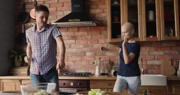 Gelukkig jong familie paar met plezier dansen in keuken. — Stockvideo