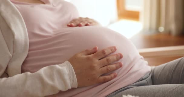 Femme enceinte caresse son gros ventre gros plan vue recadrée — Video