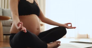 Hamile kadın evde tek başına meditasyon yapıyor, kapat.