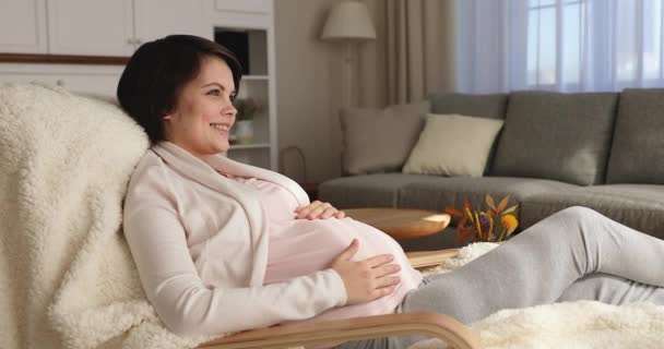 Serene pregnant woman daydreaming while resting on armchair at home — Stock Video