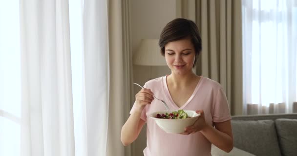 Attraente giovane donna incinta che tiene ciotola con insalata di verdure — Video Stock