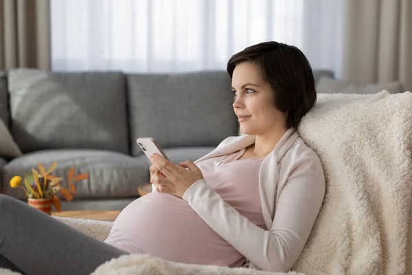 Kaukasisk gravid kvinne bruker moderne smarttelefon avslappende – stockfoto