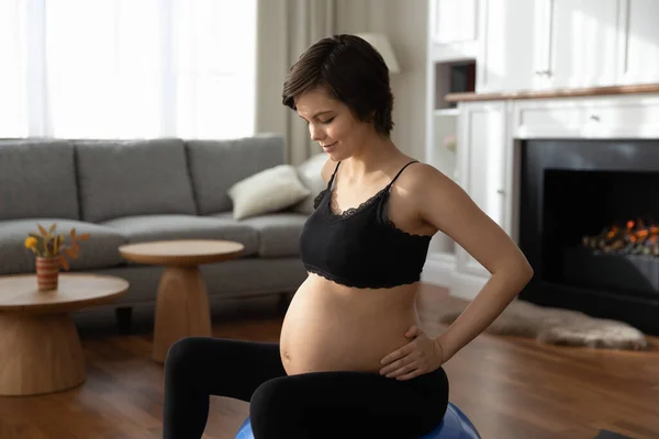 Zwangere vrouw doen gymnastiek op fitbal thuis — Stockfoto