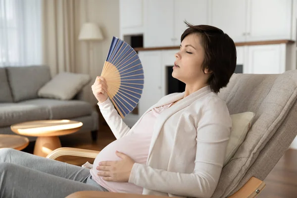 Fatigué femme enceinte utiliser ventilateur à la maison — Photo