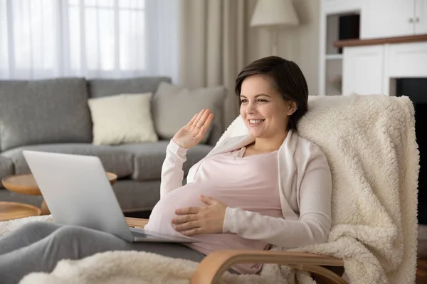 Usmívající se těhotná žena pozdravit mluvení na video hovor — Stock fotografie