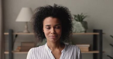 Kafadan çekilen Afrikalı iş kadını kameraya bakarak ofiste poz veriyor