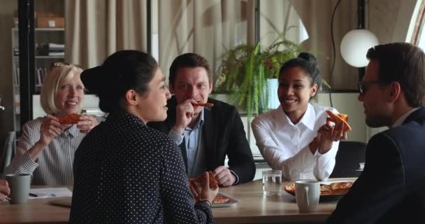 Boldog multiracionális, változatos kollégák pizzát esznek az irodában. — Stock videók