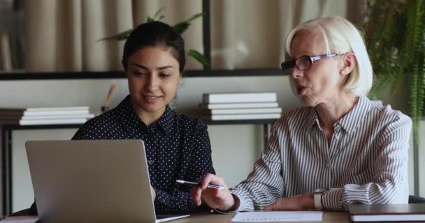 Koncentrerad äldre ledare diskuterar online-projekt med indian anställd. — Stockvideo