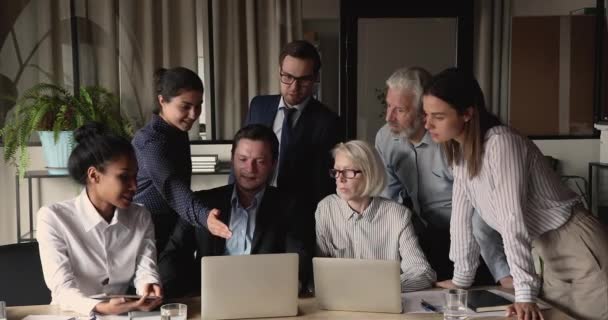 Heureux collègues divers discutant de la présentation informatique au bureau. — Video