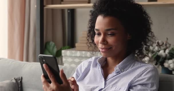 Крупный план привлекательные африканские женщины сидят на диване с мобильного телефона — стоковое видео