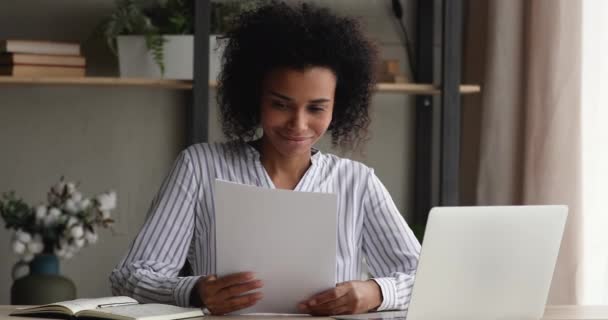 Gelukkige Afrikaanse vrouw leest goed nieuws in papieren brief — Stockvideo