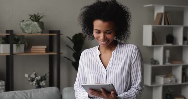 デジタルタブレットで屋内作業に立つアフリカの女性 — ストック動画