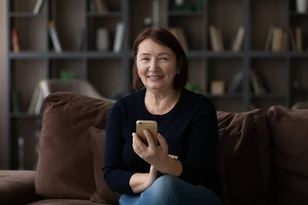 Портрет улыбающейся пожилой женщины с помощью мобильного телефона — стоковое фото
