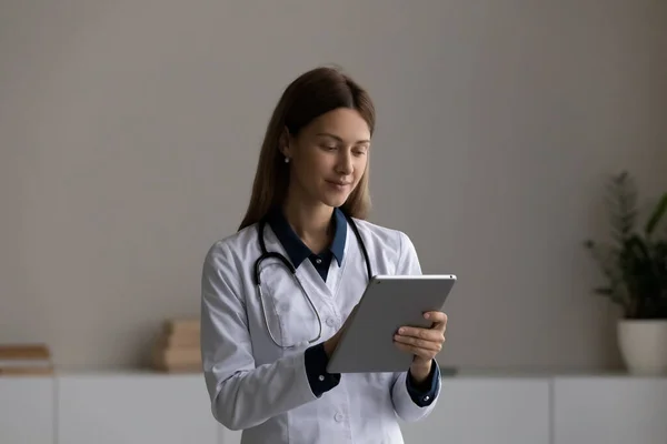 Mladá žena lékař mluvit na video hovor na podložce — Stock fotografie
