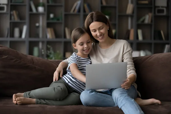 Feliz joven mamá y la pequeña hija utilizan el ordenador portátil en casa — Foto de Stock