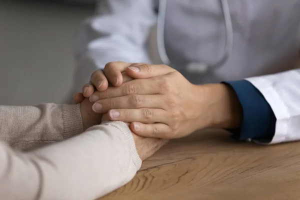 Närbild av kvinnlig läkare hålla händerna på äldre patient — Stockfoto