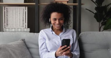 Cep telefonu tutan Afrikalı kadın. Arkadaşını selamla. Video konferansında konuşmaya başla.