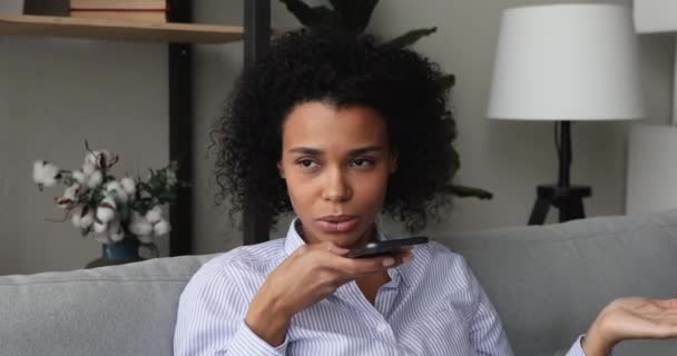 Mujer africana sosteniendo teléfono inteligente habla en speakerphone — Vídeos de Stock