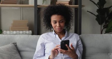 Akıllı telefon okuyan bir kadın inanılmaz bir haber alınca mutlu olur ve başarıyı kutlar.