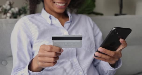 Vrouw die op internet koopt met smartphone en creditcard, close-up — Stockvideo