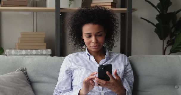 Woman holding smartphone reading unbelievable news feels happy celebrate success — Stock Video