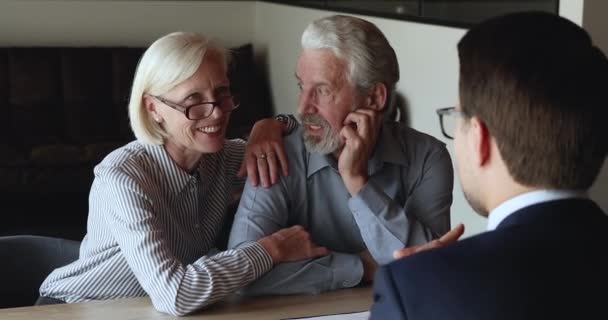 Pareja mayor concentrada consultando con asesor financiero. — Vídeos de Stock