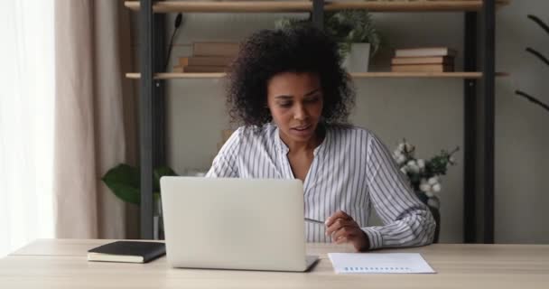 Femme d'affaires africaine faire de la paperasserie à l'aide d'un ordinateur portable analyser les données statistiques — Video