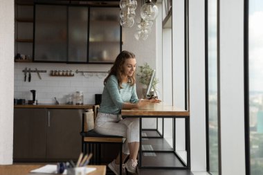 Genç bir kadın cep telefonu mesajlaşmasını aygıt üzerinde kullanıyor