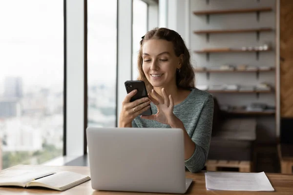 Ofisteki modern akıllı telefondan gülümseyen kadın çalışan metni — Stok fotoğraf