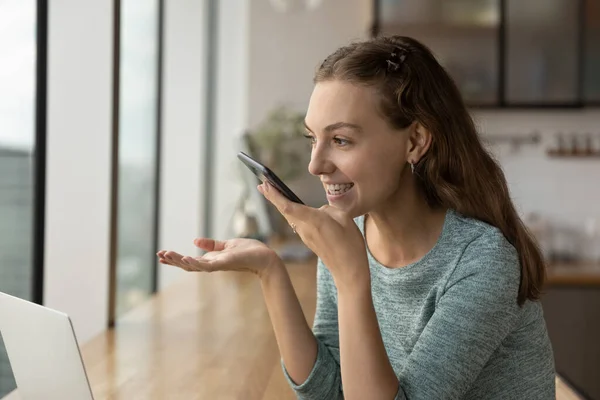 Smiling woman talk on loudspeaker on cellphone — Stock Photo, Image