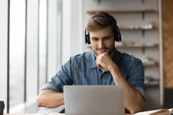 Smiling male in earphones study online on laptop — Stock Photo, Image