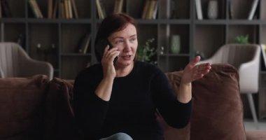 Yaşlı kadın telefonda hoş, kaygısız bir konuşma yapıyor.