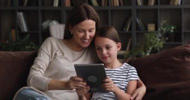 Anne ve kızını sevmek için tablet kullanıyor.