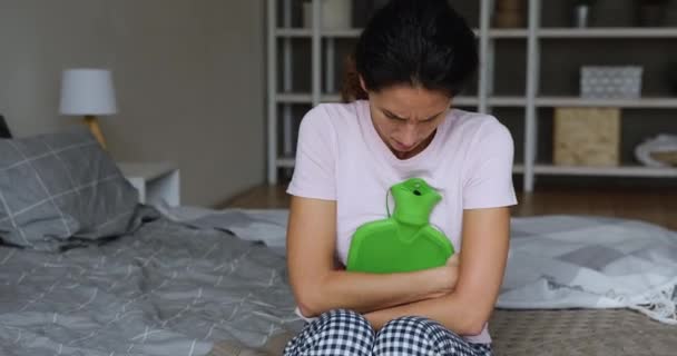 Vrouw lijdt aan menstruele krampen knuffels warmer warm water zak — Stockvideo