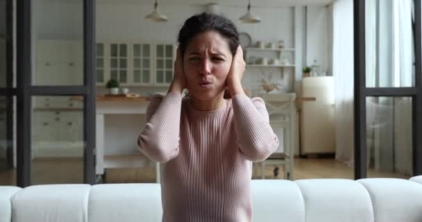 Femme couvrir les oreilles avec les mains ennuyées par les voisins bruyants — Video