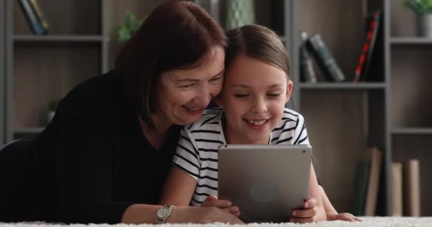 Cuidar de la abuela y la nieta divirtiéndose con el dispositivo de tableta — Vídeos de Stock