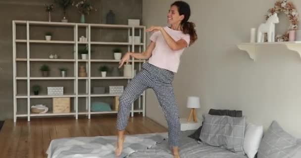 Giovane donna felice spensierata che danza sul letto — Video Stock