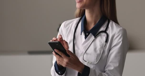 Ung kvinnlig terapeut som håller smartphone med hjälp av medicinsk mobilapp närbild — Stockvideo