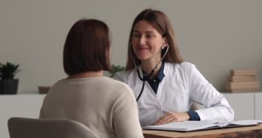 Kadın doktor steteskop tutuyor. Yaşlı hasta kalp atışlarını dinle.