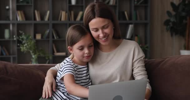 Mulher e filha usando laptop sentado no sofá em casa — Vídeo de Stock