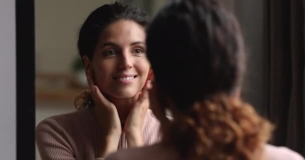 Vrouw staan in de voorkant van spiegel raakt huid bewondert zichzelf — Stockvideo