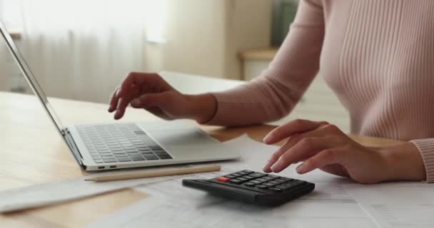Szoros női kéz használja számológép és laptop kiszámítja a költségeket — Stock videók