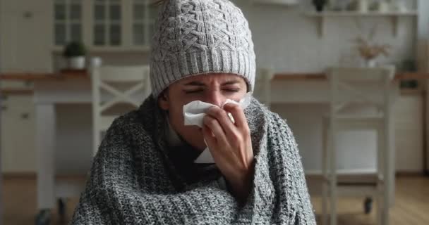 Mujer malsana envuelta en cuadros estornuda y sopla secreción nasal — Vídeo de stock