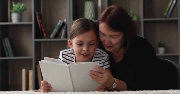 Petite fille lisant un livre à mamie plus âgée — Video