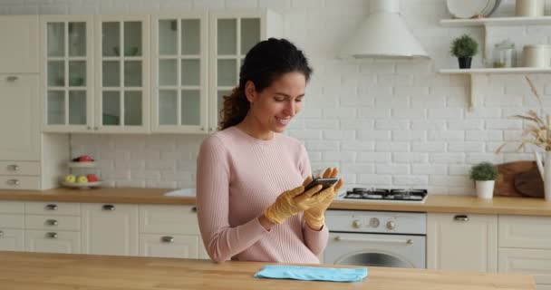 Během domácích prací hospodyňky chatování s přítelem pomocí smartphonu — Stock video